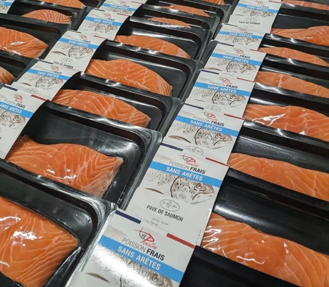 Rangées de portions de saumon en barquettes SkinPack étiquetées