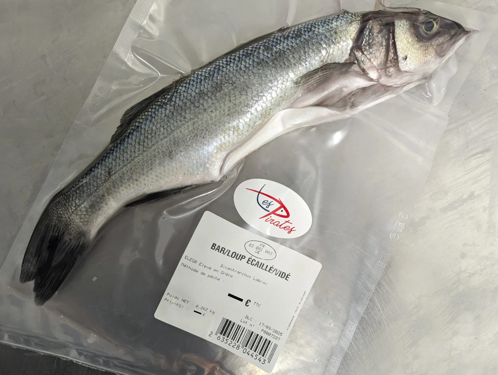 Bar ou loup entier conditionné sous vide avec une étiquette Les Pirates
